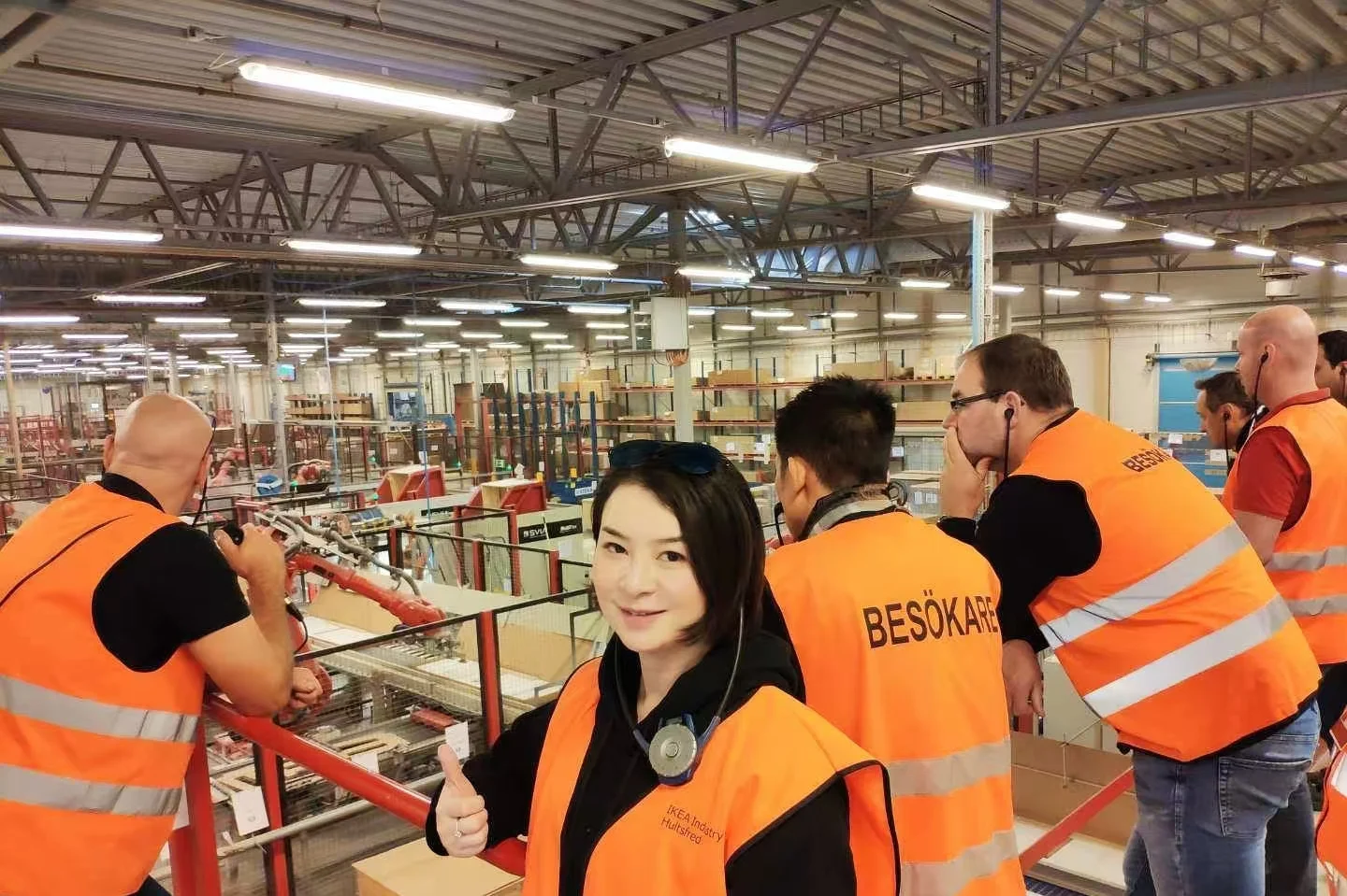 Visitors in safety vests inside a workshop