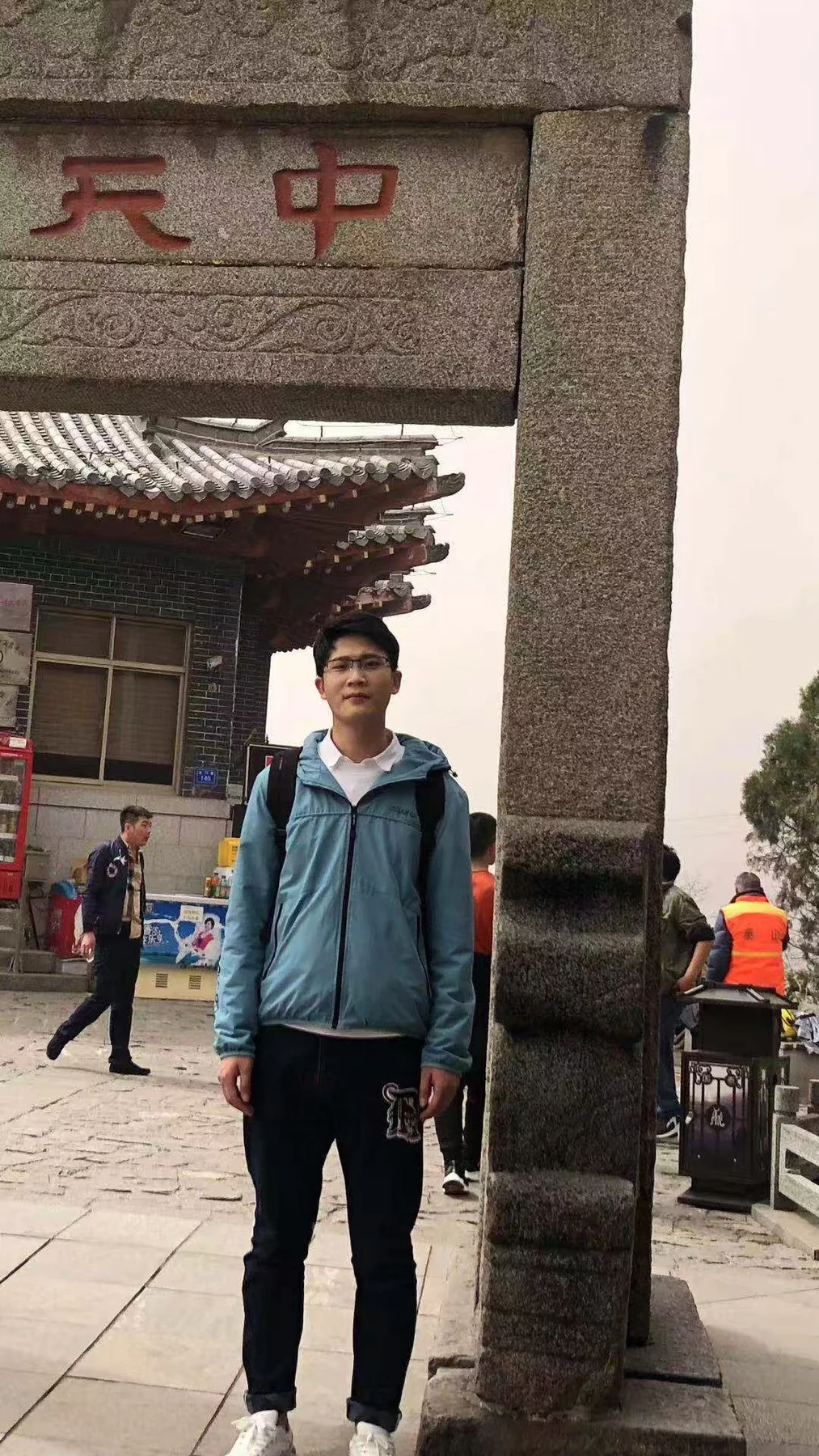 Young man with a backpack beside a traditional building