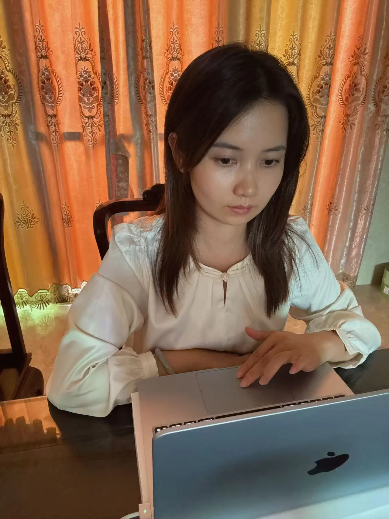 Woman looking down while seated indoors