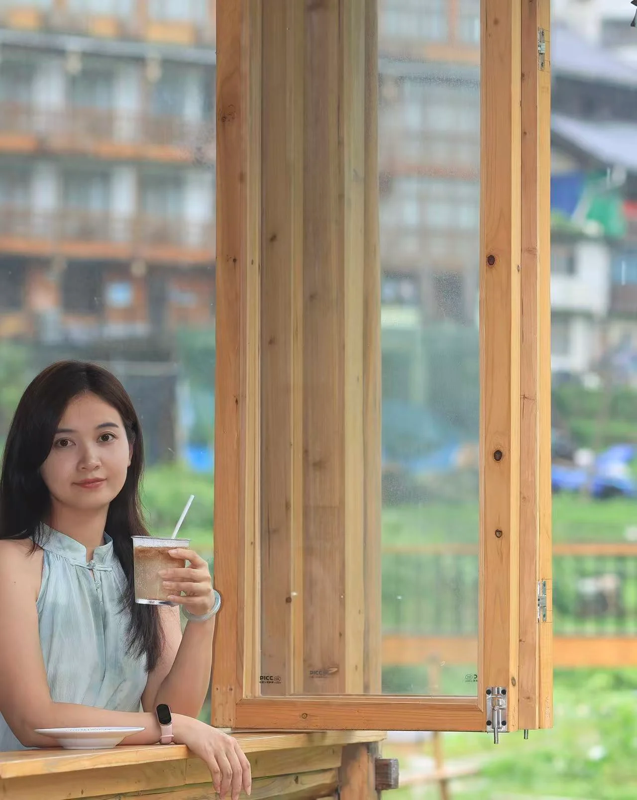 Woman standing by a window with a drink