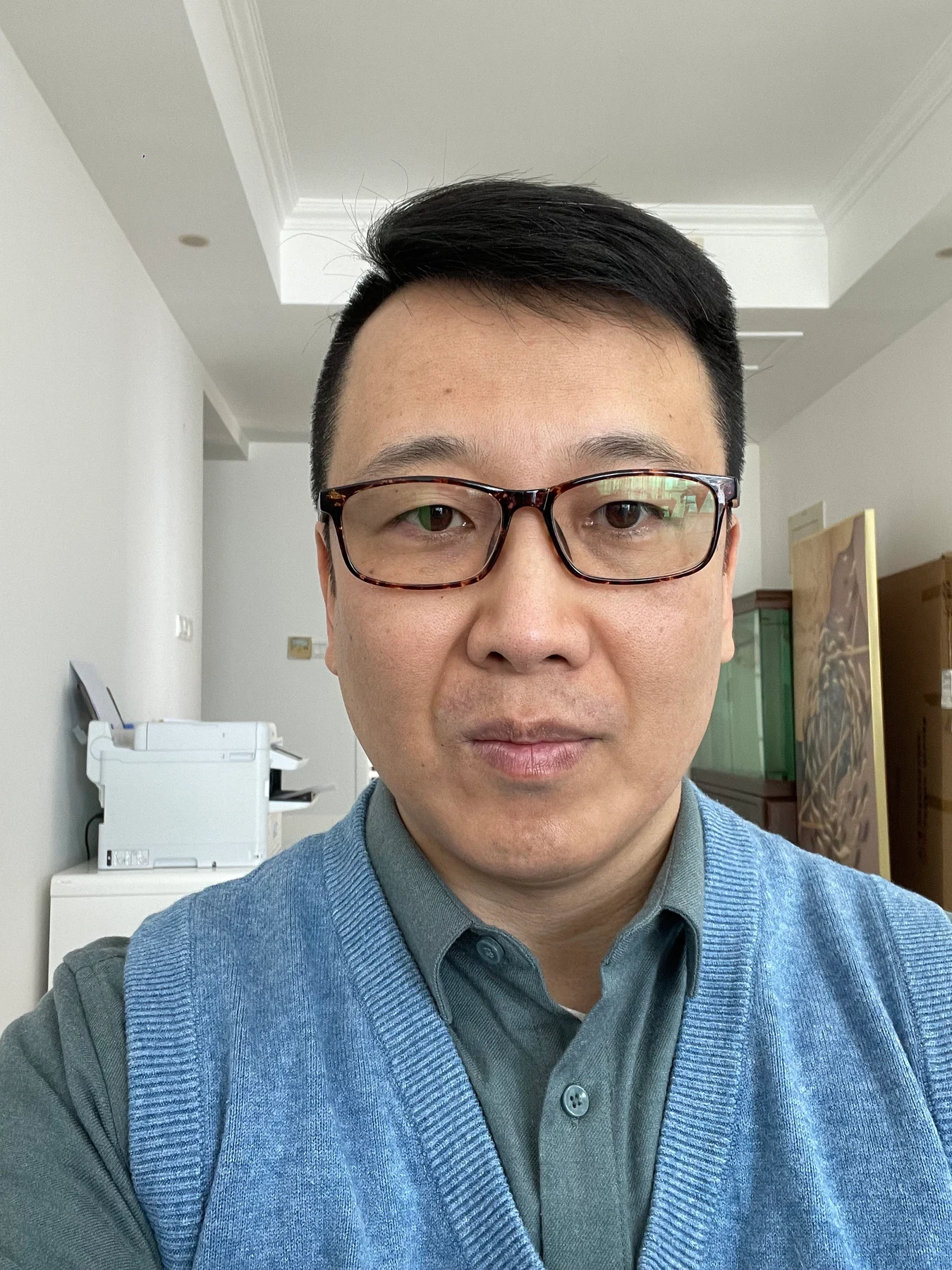 Man wearing glasses facing the camera indoors